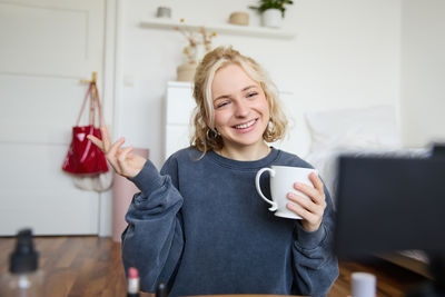 Portrait of smiling young woman using mobile phone