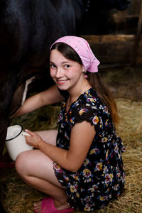 Cute ukrainian girl milk a cow in countryside
