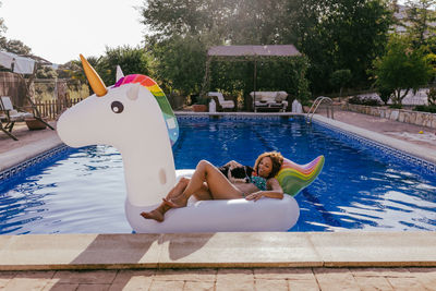 Young woman lying on swimming pool