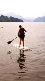 Rear view of woman standing in lake