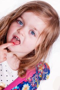 Close-up portrait of cute girl pointing at tongue