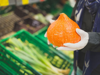 Close-up of man holding orange leaf at store