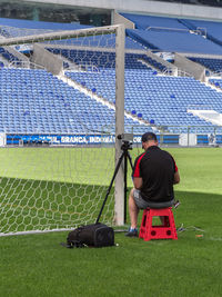 Rear view of man sitting on field