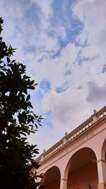 Low angle view of building against cloudy sky