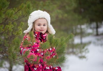 Portrait of girl smiling while standing by trees