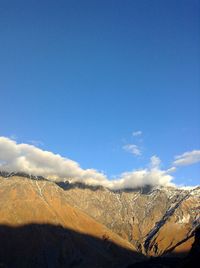 Scenic view of mountains against blue sky