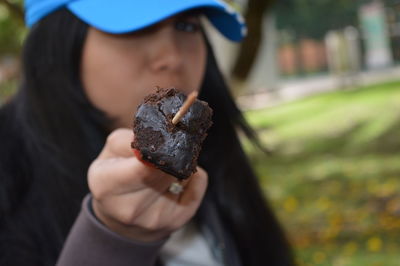 Close-up of woman with chocolate in skewer at park