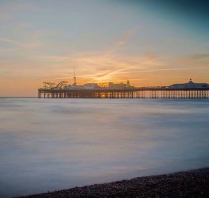 Pier on sea at sunset