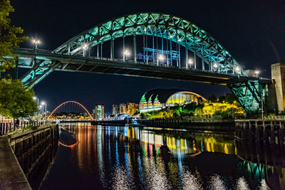 Arch bridge over river at night