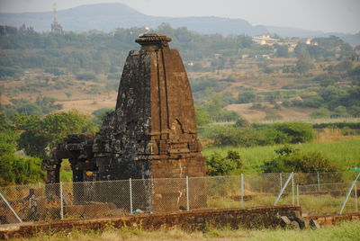 Built structure on landscape against the sky