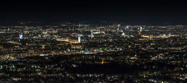 Illuminated cityscape against sky at night