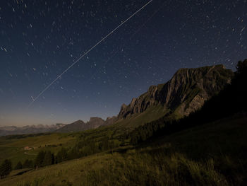 Scenic view of moonlit mountains against starry night sky 