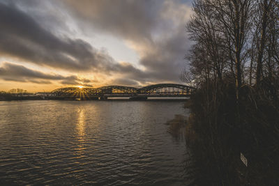 Bridge over river against sky during sunset