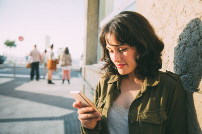 Young woman using mobile phone outdoors