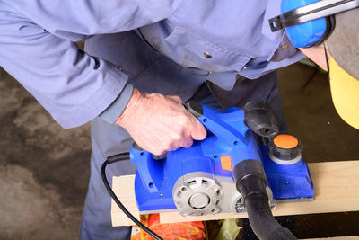 Midsection of man working on metal structure