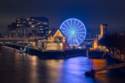 Illuminated bridge over river at night