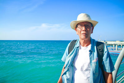 Portrait of man standing by sea against sky