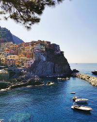 Scenic view of sea and buildings against clear sky