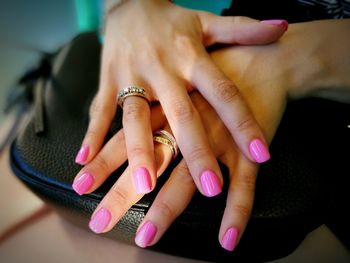 Cropped hands of woman with pink nail polish