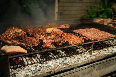 Close-up of meat on barbecue grill at night