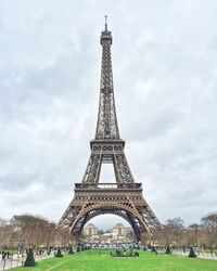 Low angle view of eiffel tower against cloudy sky