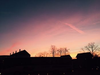 Low angle view of silhouette buildings against sky at sunset