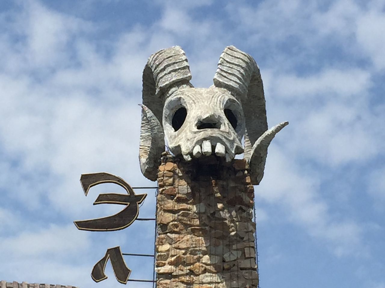 low angle view, sky, cloud - sky, sculpture, art and craft, religion, spirituality, art, cloud, architecture, built structure, human representation, place of worship, day, building exterior, outdoors, statue, creativity, no people