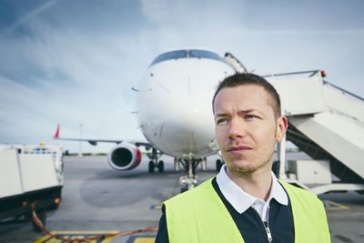Thoughtful young man against airplane