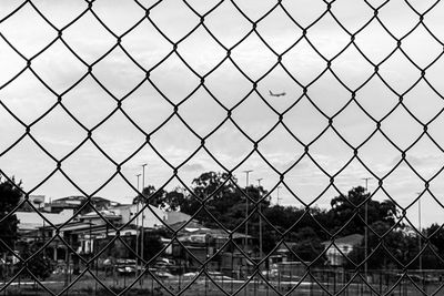 Close-up of chainlink fence with a plane framed
