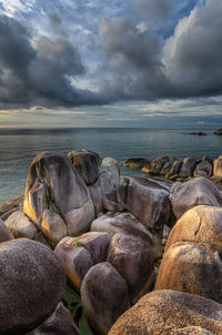 Rocks by sea against sky