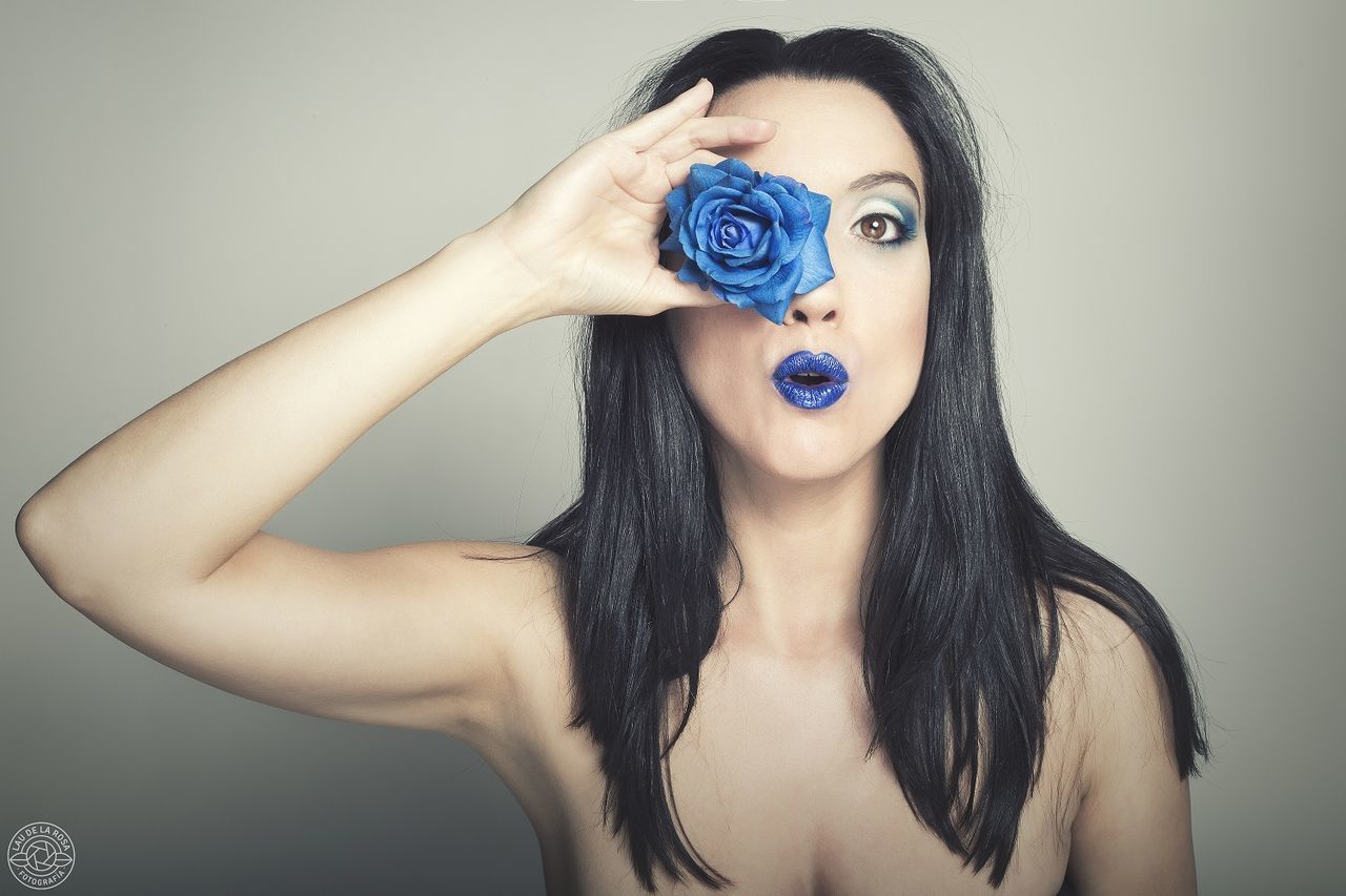 PORTRAIT OF BEAUTIFUL YOUNG WOMAN HOLDING GRAY BACKGROUND