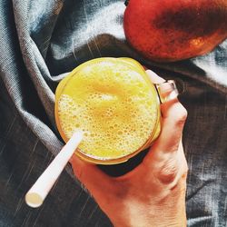 High angle view of hand holding drink on table