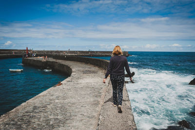 Rear view of man standing on pier