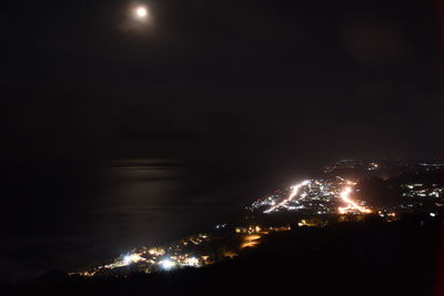 Illuminated cityscape against sky at night