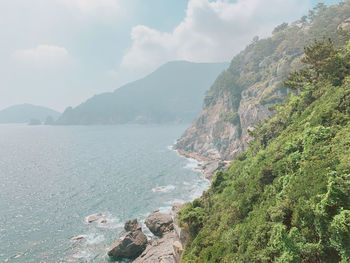 Scenic view of sea and mountains against sky