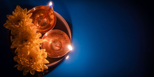 Close-up of illuminated light bulb against blue background