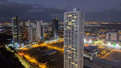 High angle view of illuminated buildings against sky at night