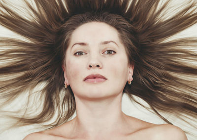 Middle-aged woman with long hair, combed hair on white background