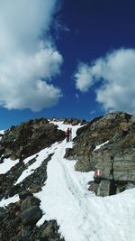 People on cliff against sky during winter