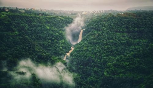 Scenic view of waterfall against sky