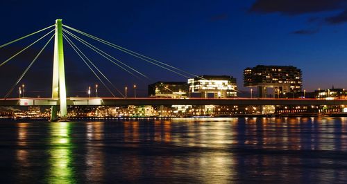 Illuminated bridge over river at night