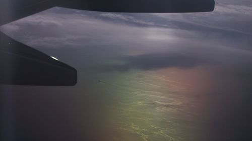 Close-up of airplane wing against sky during sunset