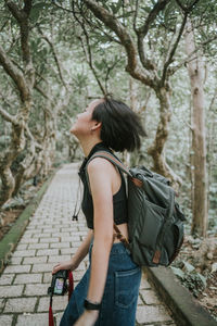 Rear view of woman standing by tree