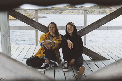 Smiling women sitting on jetty