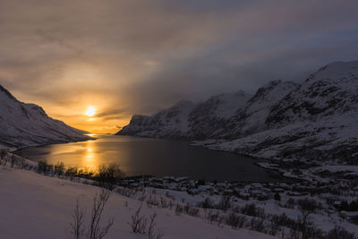 Scenic view of snowcapped mountains against sky during sunset