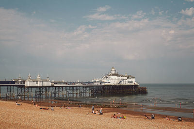 Eastbourne pier at beach against sky