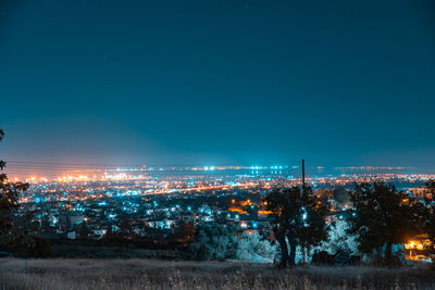 High angle view of illuminated buildings against clear sky at night