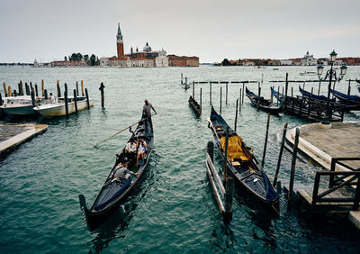 Boats moored in canal against buildings