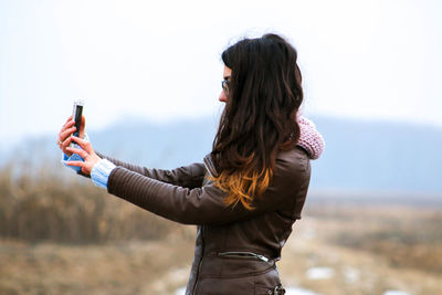 Young woman taking selfie outdoors