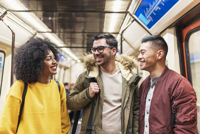 Happy friends standing in train